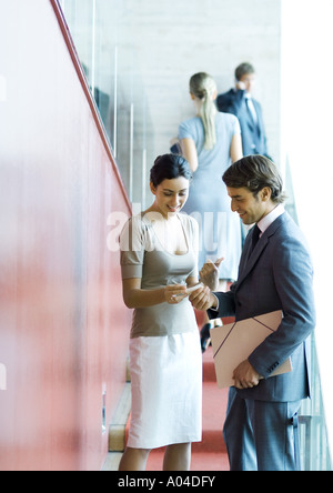 Executives standing, speaking and exchanging business card Stock Photo