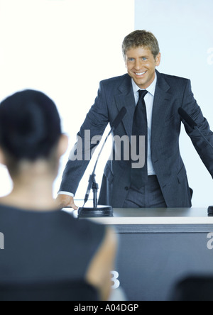 Businessman standing next to microphone in seminar Stock Photo