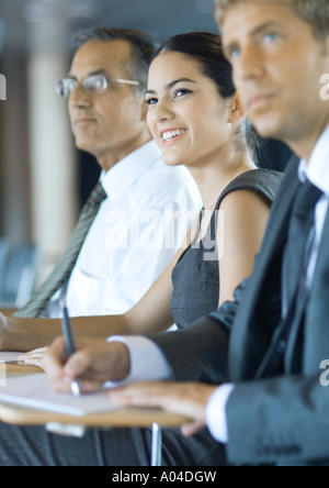 Executives sitting, taking notes Stock Photo