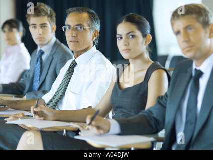 Executives sitting in seminar Stock Photo
