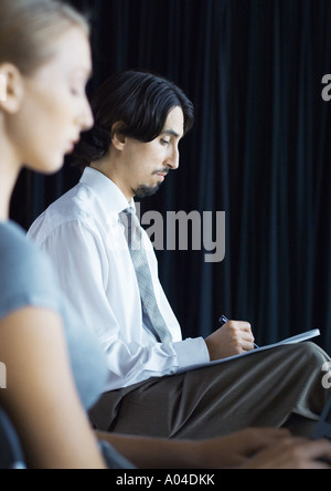 Businessman sitting, taking notes Stock Photo