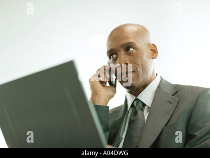 Man using laptop and cell phone Stock Photo