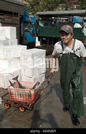 dh Fish market ABERDEEN HONG KONG Chinese boy porter with fish leaving market workers china worker Stock Photo