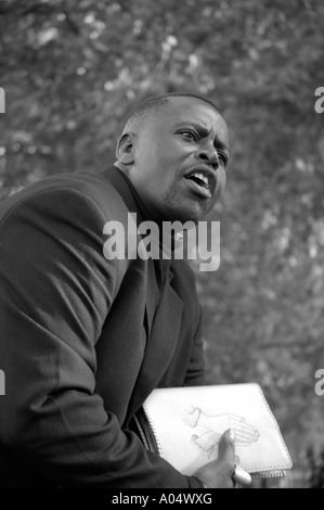 Well dressed black evangelical Christian preacher holding white Bible speaking at Speaker's Corner, Hyde Park, London, England Stock Photo