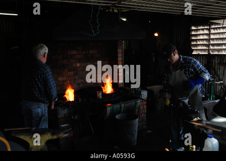 two men working in a blacksmith shop Stock Photo