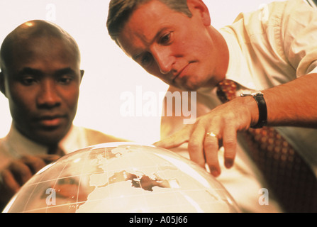 Two business men an African American and a Caucasian examining a world globe Stock Photo
