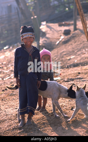 Akha girls with dogs. Muang Sing district, Luang Nam Tha, Laos. Stock Photo