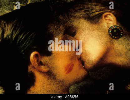 Close up portrait of a couple engaged in a passionate kiss with an imprint of lipstick on the man cheek Stock Photo