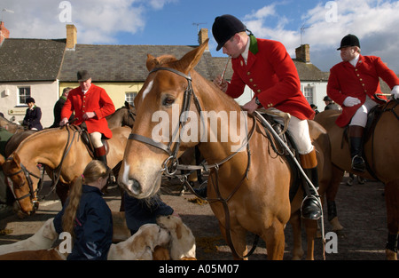 Huntsmen on horseback in red coats with hounds gather for fox hunt meeting in UK Stock Photo