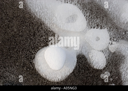 Face formed of snow and air bubbles trapped underneath ice , Finland Stock Photo