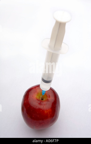 Apple being injected with a clear liquid. Stock Photo