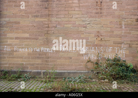 Solidarity expressions spray painted on an abandoned factory wall in urban Dundee, UK Stock Photo