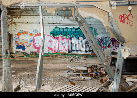 Mangled framework and thick bold graffiti spray painted on the walls of an abandoned derelict warehouse in urban Dundee,UK Stock Photo