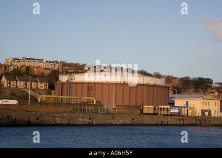 Large circular rusted brown and white container tank at the Dundee docks,Scotland UK Stock Photo