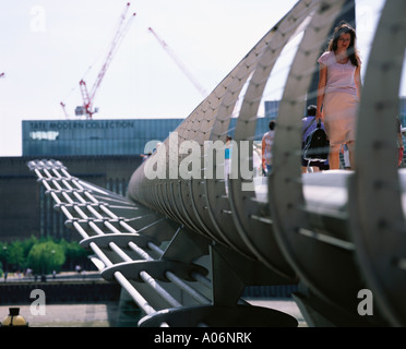 Woman crosses Millenium Bridge from Tate Modern London Stock Photo