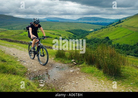 Female mountain biker on a track above Wandale in the Howgill Fells in Cumbria Stock Photo