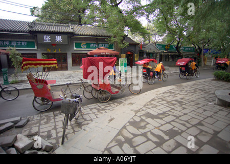 Rickshaws driving through the Hutongs Stock Photo