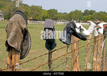 Old boots on a wooden and barbed wire fence, Texas Stock Photo