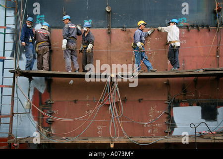 graphic detail shot of ship welder and ship welding  painting protective coating being applied at Hong Kong United Dockyard HUD Stock Photo