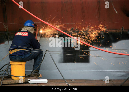 graphic detail shot of ship welder and ship welding  painting protective coating being applied at Hong Kong United Dockyard HUD Stock Photo