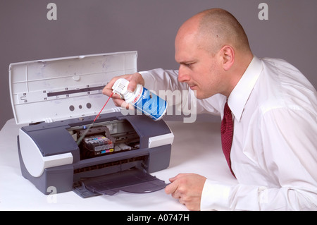 Man Cleaning Computer Printer With Compressed Air 4 Stock Photo