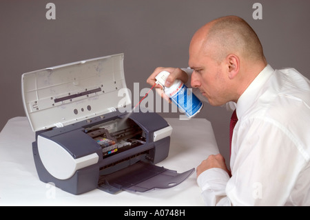Man Cleaning Computer Printer With Compressed Air Stock Photo