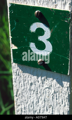A small green sign displaying the number three Stock Photo