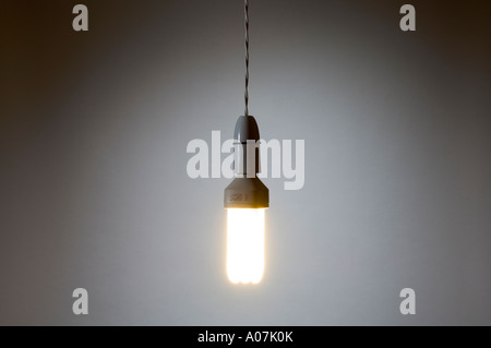 A fluorescent, energy-saving light bulb hanging by a twisted flex wire Stock Photo