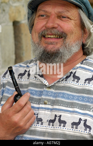MR old good humoured bearded man smoking a pipe Stock Photo