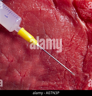 close up of meat beef with a syringe jab shot in front of the piece of meat Stock Photo