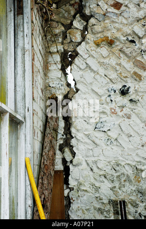 Large vertical crack in brick wall with diagonal laid bricks Stock Photo