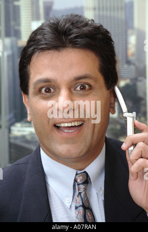 CEO smiling portrait talking on cellphone in his cabin in business suit Stock Photo