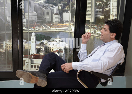 CEO thinking sitting in his cabin with city background Stock Photo