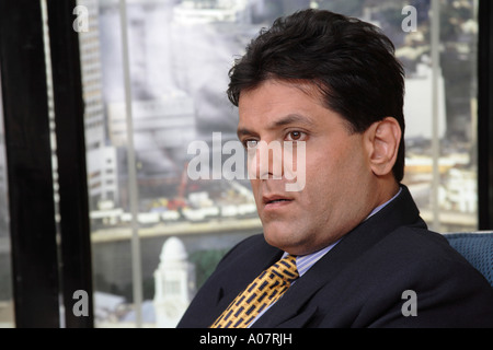 CEO thinking sitting in his cabin in business suit with city background Stock Photo