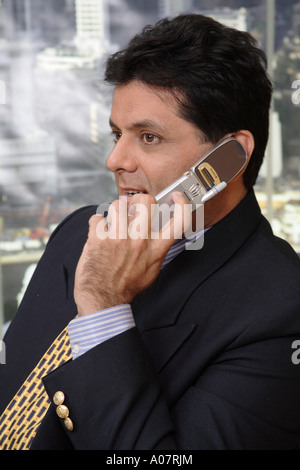 CEO portrait on cellphone in his cabin in business suit Stock Photo