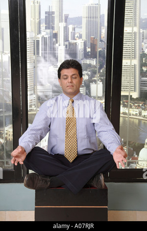 man doing yoga in his cabin with city background - MR# Stock Photo