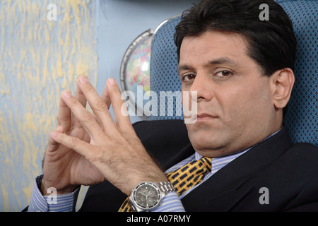 CEO lost in thought in his office cabin in business suit Stock Photo