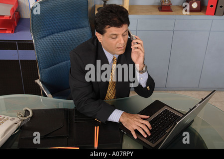 CEO working on computer in his office cabin in business suit Stock Photo