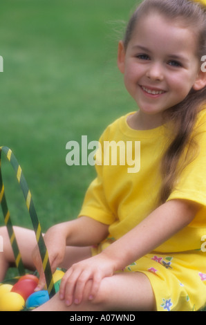 Easter Sunday with kids enjoying an Easter egg hunt in families backyard. Stock Photo