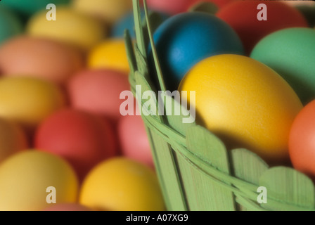 Colorful eggs in green wooden basket close up on Easter Sunday Stock Photo