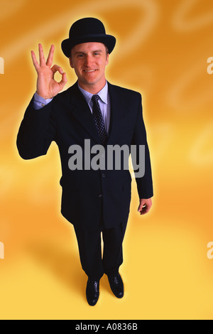 Businessman standing with hand in OK sign Stock Photo