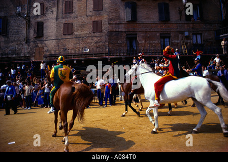 Siena Italy Tourists and Locals watching the Palio di Siena a Horse Raceheld twice a year at the Piazza Del Campo each Jockeys Represents One of the T Stock Photo