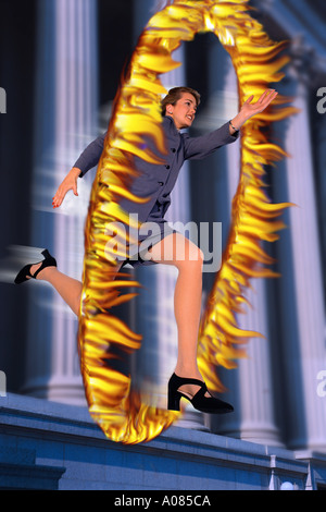 Businesswoman jumping through hoop of fire Stock Photo