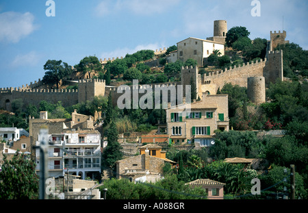 A view of the largest fortress in Mallorca crowning its wooded hillside overlooking the small town of Capdepera Stock Photo