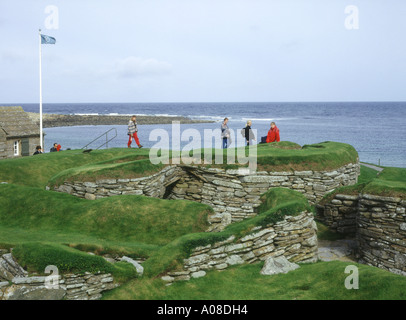dh Bay of Skaill SKARA BRAE ORKNEY Tourists Prehistoric neolithic village settlement stone house rooms ruins Stock Photo