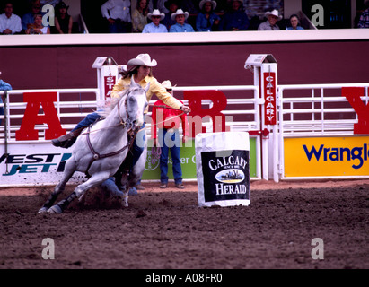 Calgary Stampede, Alberta, Canada - Rodeo Cowgirl riding Horse in Ladies Barrel Racing Event, Race in Outdoor Arena Stock Photo