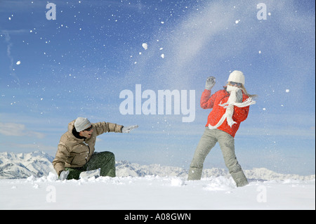 Junges Paar hat Spass bei einer Schneeballschlacht, young couple enjoying snowball fight Stock Photo