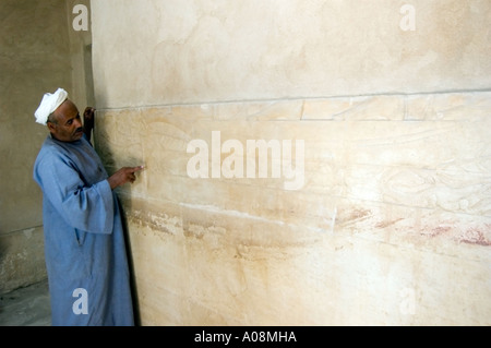 Guide with ancient inscriptions inside a tomb at the Pyramid complex at Saqqara, near Cairo, Egypt, Africa. Stock Photo