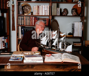 Retired pensioner busy building a ship model in his home Stock Photo