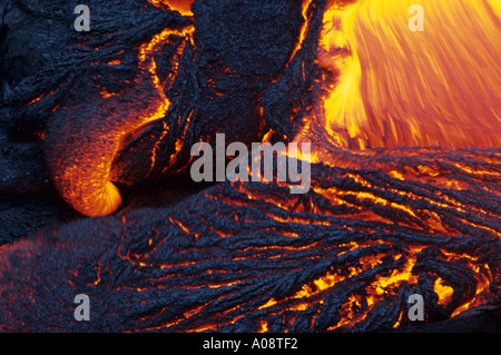 Molten Pahoehoe lava flowing at night from the erupting Kilauea Volcano, in Volcanoes National Park, Hawaii, USA Stock Photo